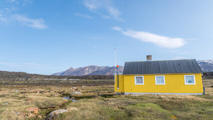 Serene landscape of Saqqaq with yellow house in Greenland