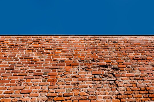 Fragment of historic stone medieval city wall in Poznań Greater Poland in Poland with clear sky, Minimalist design backdrop for history or construction companies