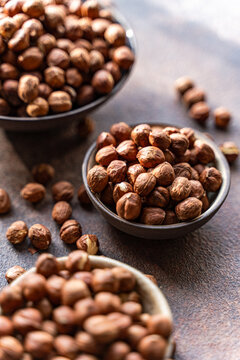 Organic hazelnuts in bowls with rustic background
