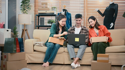 SME team discussing packaging and tracking customer orders at home office, reviewing parcels and logistics workflow together