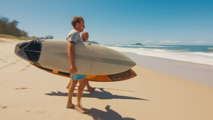 Young and elderly surfers walk with surfing boards on the beach in Brazil