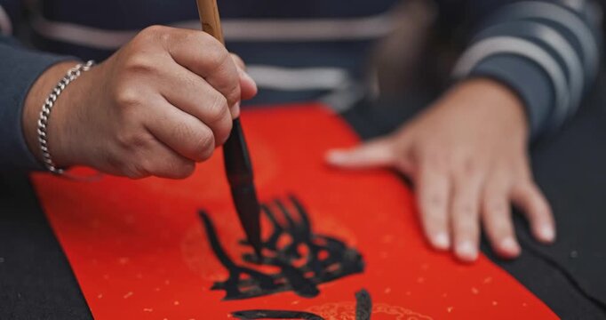 Writing Chinese calligraphy with phrase meaning may you have a prosperous New Year