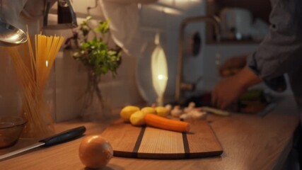 Male cook gently rinses fresh vegetables under the kitchen tap, surrounded by prepped ingredients on the countertop, amidst warm ambiance of home kitchen highlighting culinary preparation food cuisine
