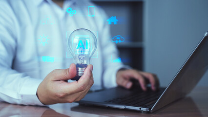 Businessperson holding glowing light bulb near laptop with futuristic icons, symbolizing innovation, ideas, and digital transformation.