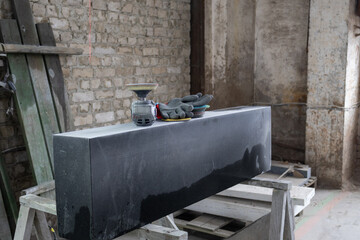 Black stone block on workbench with tools in construction site during daytime