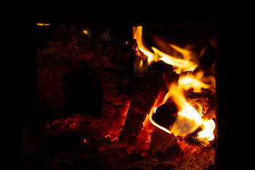 Flames dance in a fireplace as logs burn during a cozy evening in a home setting in winter