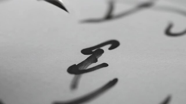 Close-up view of handwritten text on white paper with blurred background