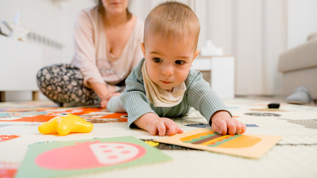 Baby playing with educational cards on the floor