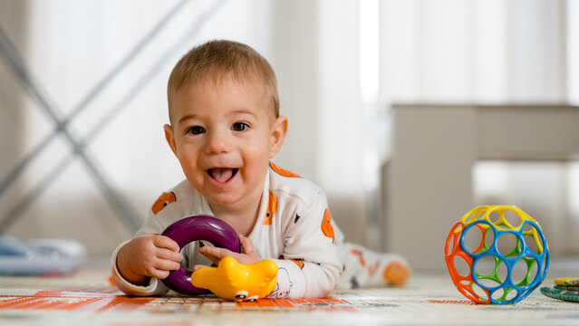 Baby playing on floor with colorful toys