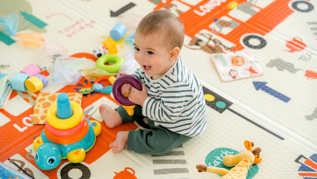 Happy baby playing joyfully in colorful playroom