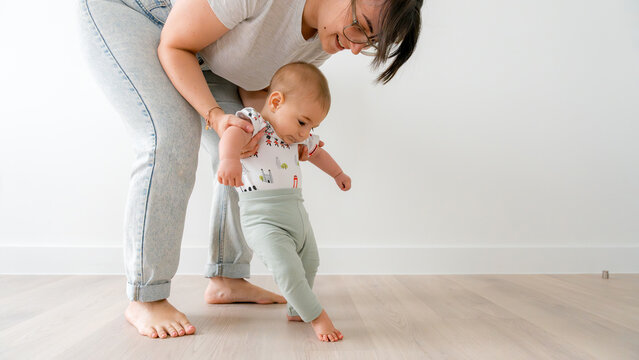 Baby learning to walk with mother support