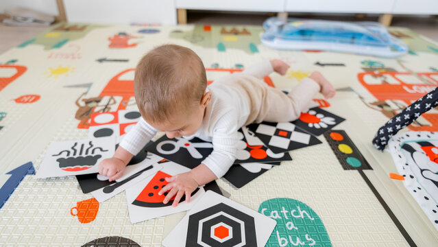 Baby exploring colorful cards on playmat