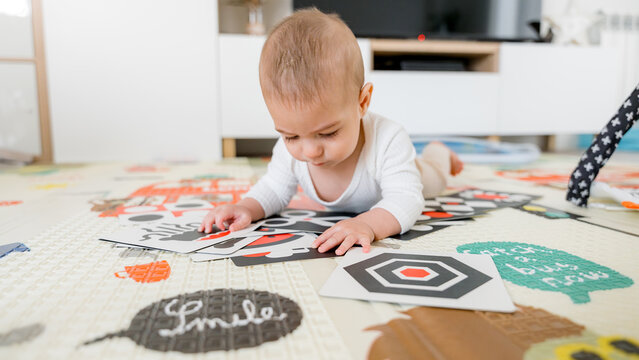 Baby exploring on colorful play mat with cards