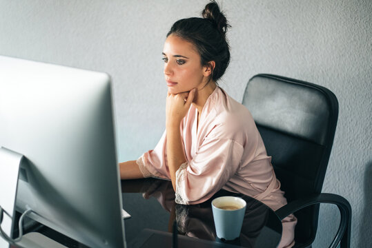 Woman relaxing at home while working on computer