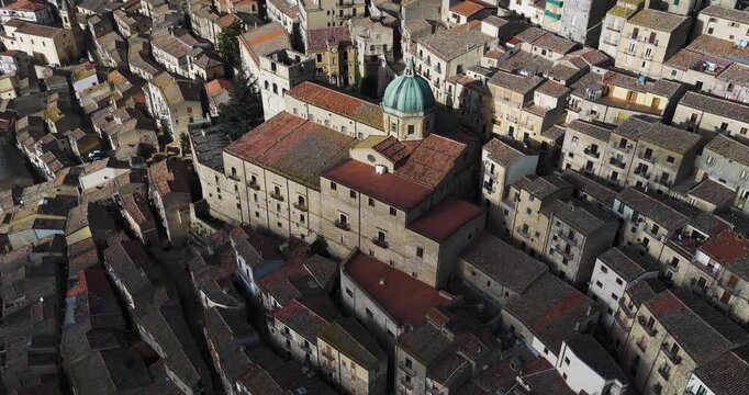 Aerial view of closely packed buildings with a dome, the varied textures and tones creating a captivating urban tableau, Gangi, Sicily, Italy.