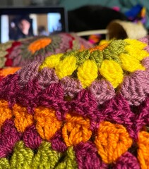 Crocheting granny squares blanket and watching film cozy photo 
