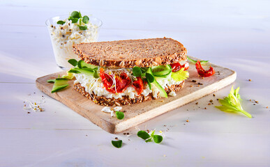 Stulle mit k&ouml;rnigem Frischk&auml;se Sprossen getrockneten Tomaten und Zucchinistreifen