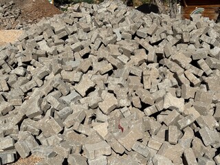 Pile of gray paving stones in sunlight, ideal for construction or landscaping background