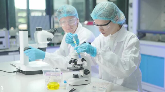 Scientists conduct experiments in a laboratory using a microscope and samples