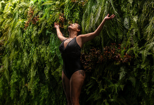 Woman relaxing indoors by vertical garden