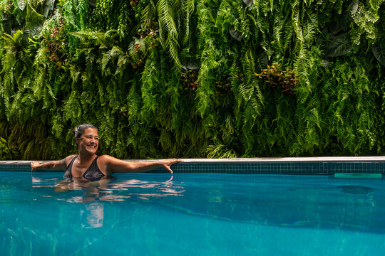 Woman enjoying indoor swimming with greenery
