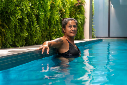 Relaxed woman enjoying indoor swimming pool