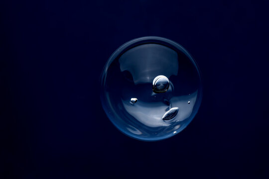 Clear bubble reflecting light against dark background