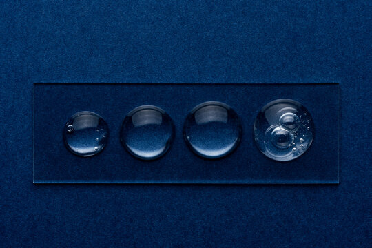 Transparent gel droplets on blue textured background