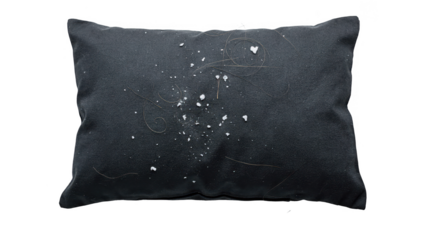 Overhead closeup of dark pillowcase with visible white flakes and loose hair emphasizing scalp health and hygiene in a clinical setting.