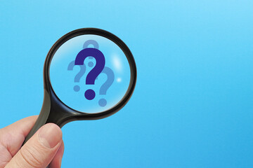 Magnifying glass and question mark on blue background