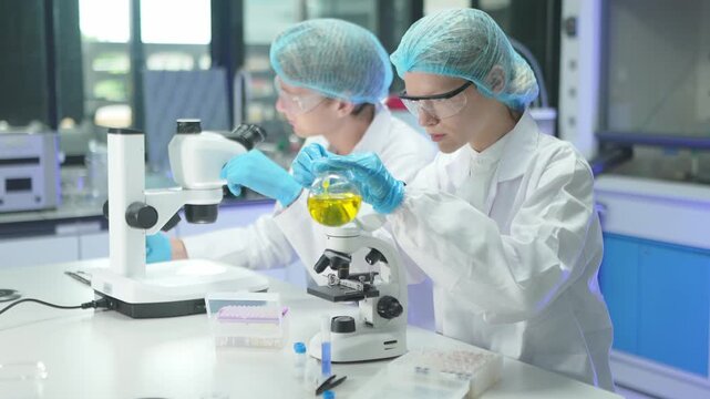 Lab workers conduct experiments with microscopes and samples in a scientific environment