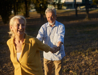 Happy active senior couple having fun in park outdoors