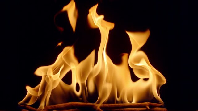 Slow motion flames dancing against a deep black background, creating a dramatic and powerful fire effect. Abstract burning fire with glowing orange and yellow tongues of flame, ideal for backgrounds, 
