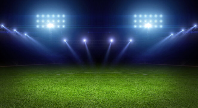 Soccer stadium field. Sports stadium with a green grass field shines and spotlights. Football stadium with floodlights and fan tribune. Soccer tournament, world championship.