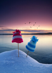 whimsical self knitted whimsical hats on the winter beach in sunset light