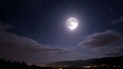 A full moon shines brightly in a starry night sky over a silhouetted landscape dotted with distant town lights