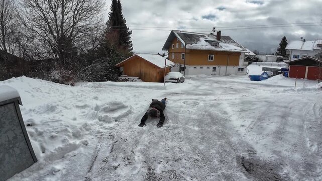 Video Rutschgefahr auf einem glatten Gehweg im Winter. Eine Frau rutscht auf einer schneeglatten Stra&szlig;e aus und f&auml;llt hin