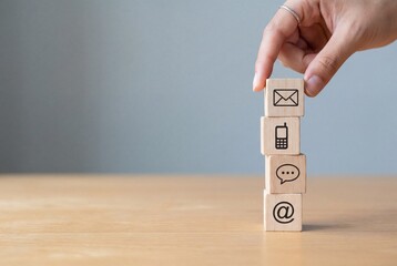 Hand placing cube on stack of blocks with communication icons