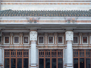 Obraz premium Palazzo delle Terme Berzieri facade showcasing Art Deco architecture with intricate details, sculpted columns, decorative motifs, and unique roof tiles at QC Terme Salsomaggiore Terme in Italy