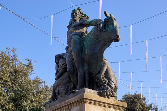 Detail of the bronze sculpture dedicated to cattle farming by frederic mares located in the emblematic plaza de catalunya during a sunny day.