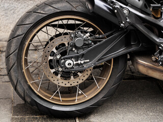 sport black bike parked. parking background. sports motorcycle with aluminum frame. shock absorber fork and brake disc on the back wheel. exhaust pipe and drive chain