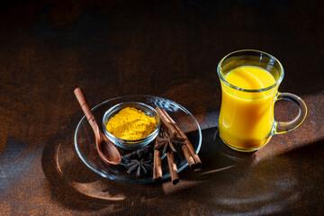 Golden Turmeric Milk Latte with Spices on Dark Table