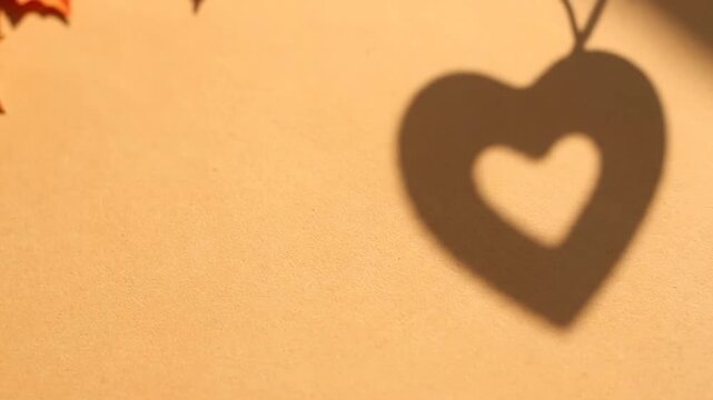 A romantic valentine heart hangs on a wall with warm lighting.