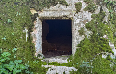 Prehistoric nuraghe stone structure rising from green landscape under dramatic sky in Sardinia