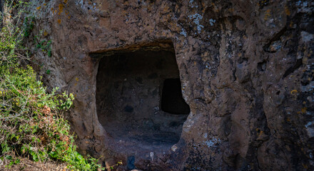 Prehistoric nuraghe stone structure rising from green landscape under dramatic sky in Sardinia