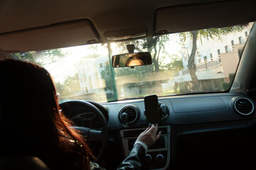 Content creator driver adjusting their smartphone inside the vehicle to create content while driving and talking to their audience.