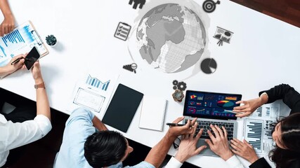 A top view of a diverse group of professionals engaged in a meeting. They utilize laptops and tablets to analyze data and discuss strategies for global business success. Raster - Powered by Adobe