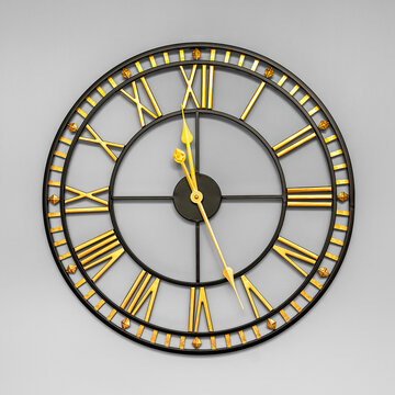 Gold and black metallic round skeleton wall clock with roman numerals and minute scale on a wall. Grey background.