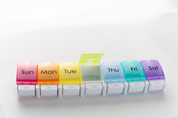 Weekly pill organizer box on white background