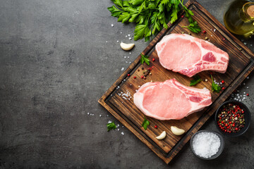 Raw pork steak. Fresh meat on cutting board with spices.